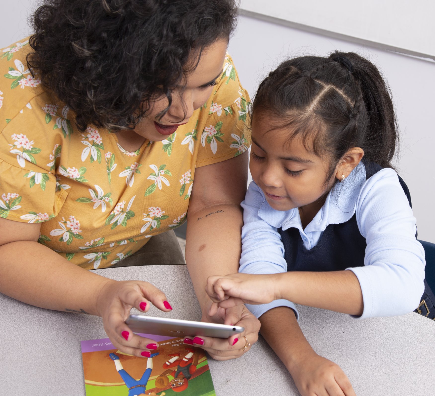 A teacher and a student using a tablet.