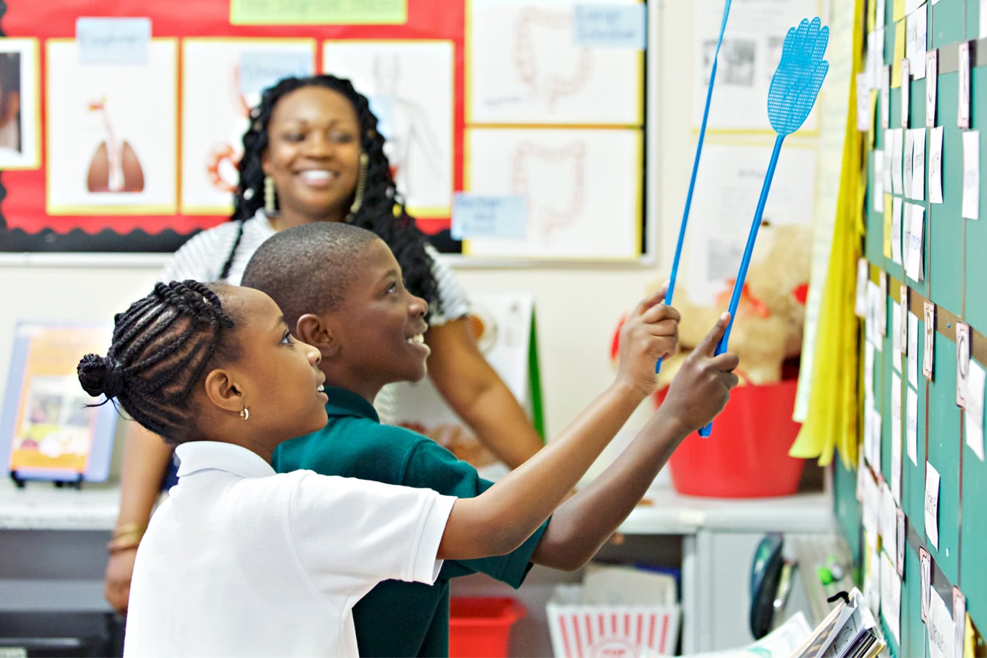 A teacher watching two students using the board to learn