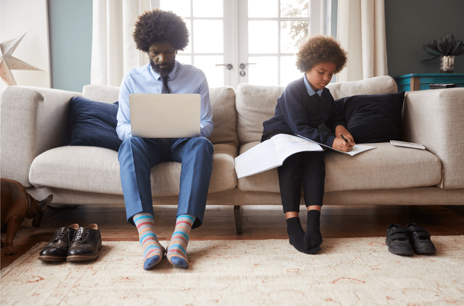 Parent and child at home working on sofa