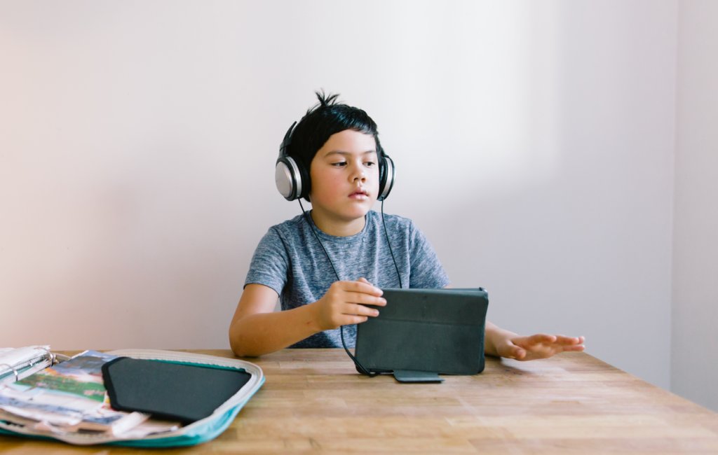 Child listening to audio on tablet