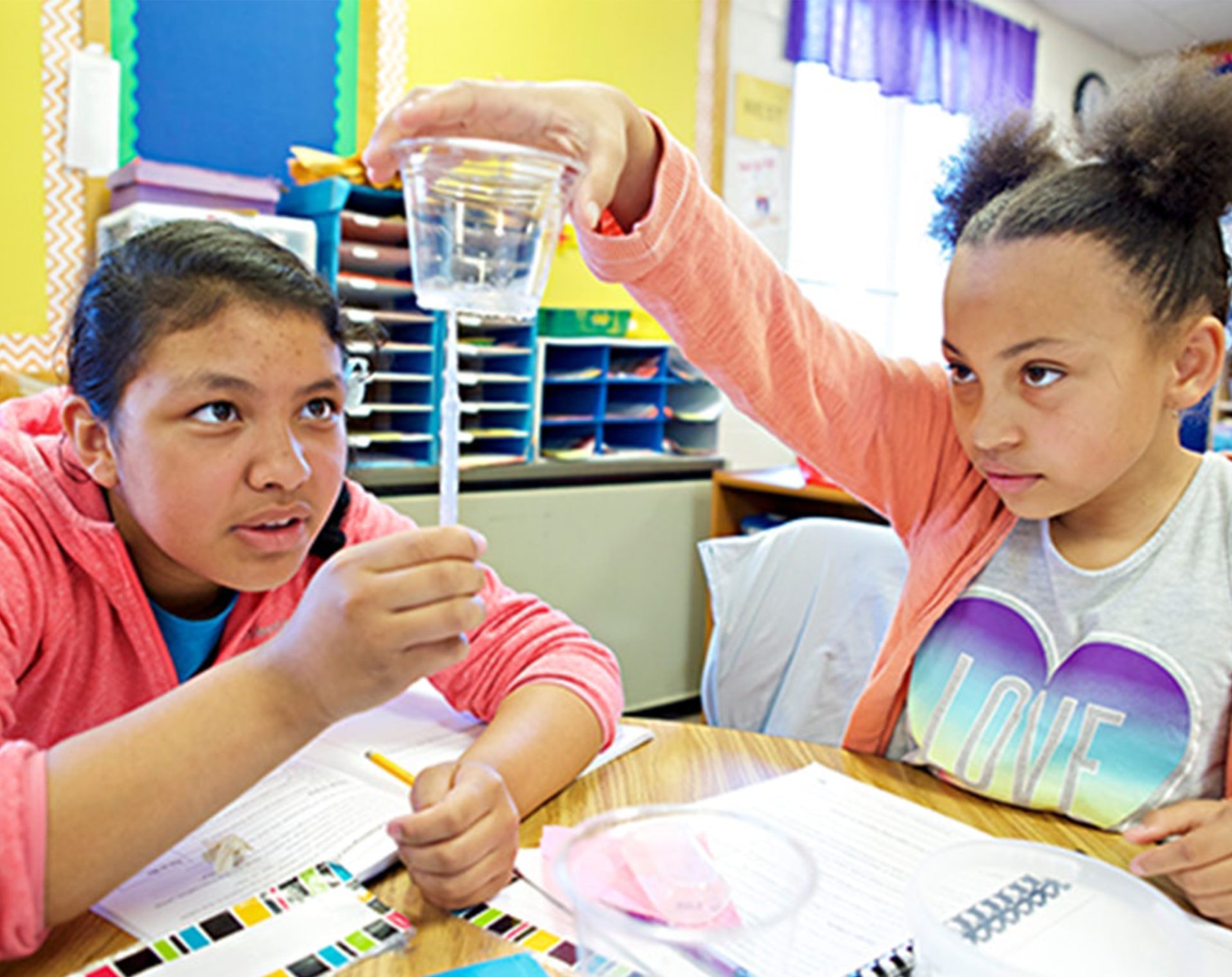 two female students analyzing a cup of water